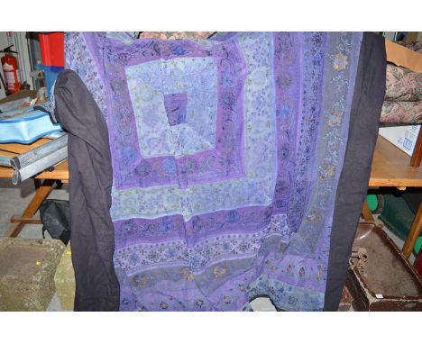 A 20th Century Indian embroidered bed spread, in blue and purple with floral motifs.