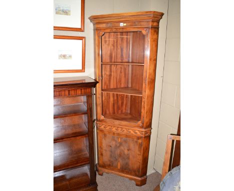 A reproduction yew wood corner display cabinet, the dental cornice above glazed panel door enclosing shelves, above Vitruvian