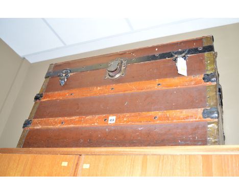 A dome top travel trunk, with metal bindings and leather cloth cover.