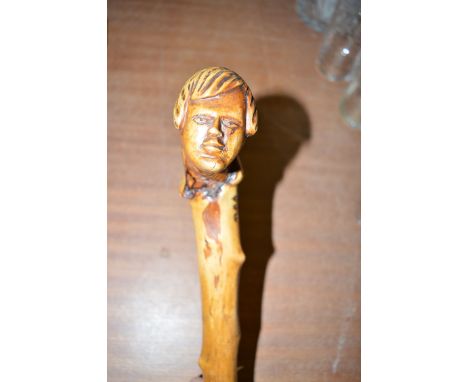 A rustic walking stick, the handle carved as male bust.