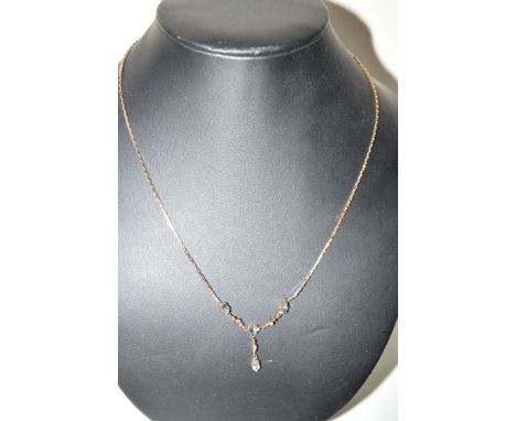 An aquamarine and diamond set necklace on baton link chain, bears hallmarks for 9ct. gold.