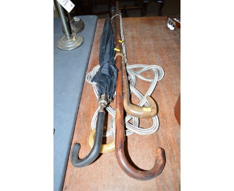 Three rustic walking sticks various; an umbrella; and a carpet beater.