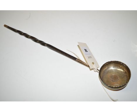 A white metal toddy ladle, the bowl set George II coin, with twisted whalebone handle.