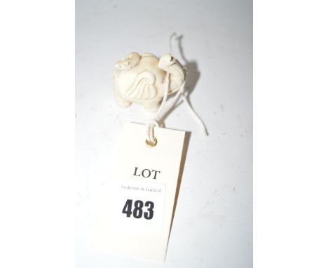 A small early 20th Century carved ivory netsuke in the form of an elephant with a rat on its back.