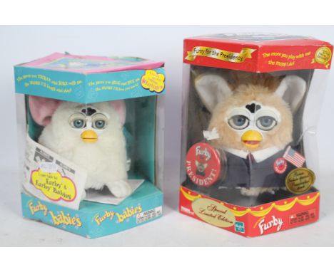 A collection of two Furby babies toys to include model 70-940 in white and #70665 In damaged box which has been opened. Item 