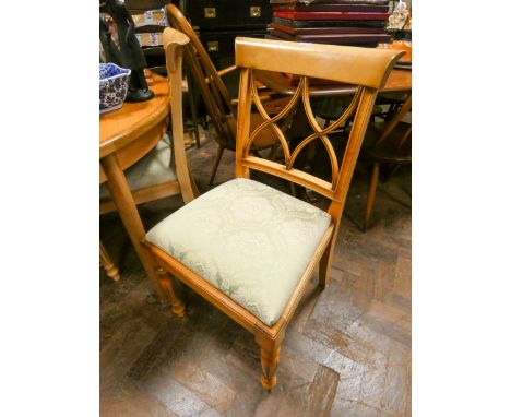 A set of four light beech dining chairs with green upholstered seats 