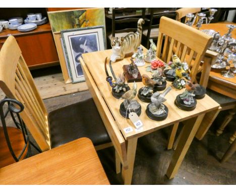 A modern light oak drop leaf kitchen table and a pair of similar slat back chairs with brown upholstered seats 