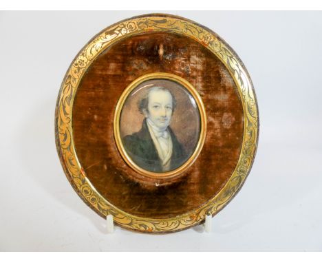 A 19th Century portrait miniature on ivory, the oval panel depicting a Regency gentleman in a brass and velvet frame, miniatu