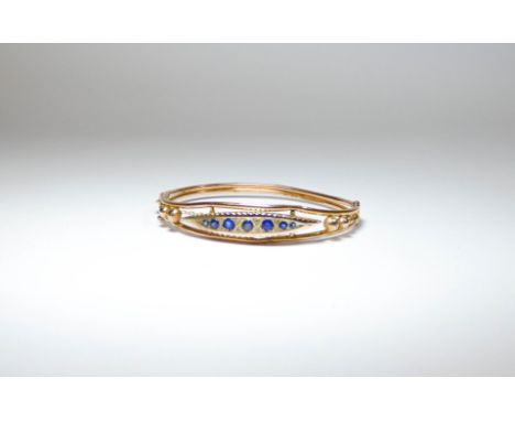 Edwardian 9ct gold ladies  bangle, inset with a panel of sapphires, with snap clasp and safety chain, in leather box  Sapphir