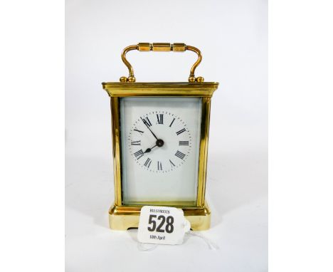 A brass carriage clock in its original red maroon leather carrying case, overall height 11cms 