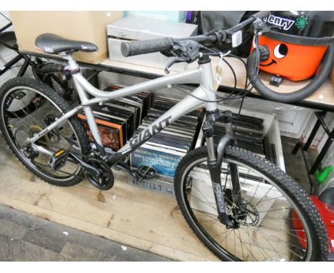 A silver and black giant boulder gents bicycle with front suspension 