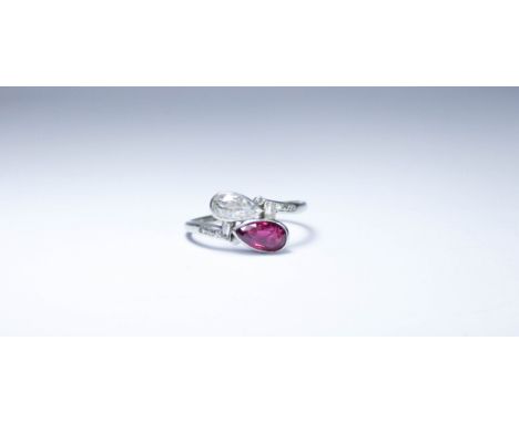 Art Deco ruby and diamond ring, set with a tear drop shaped diamond and companion ruby in a cross over design with baton shap