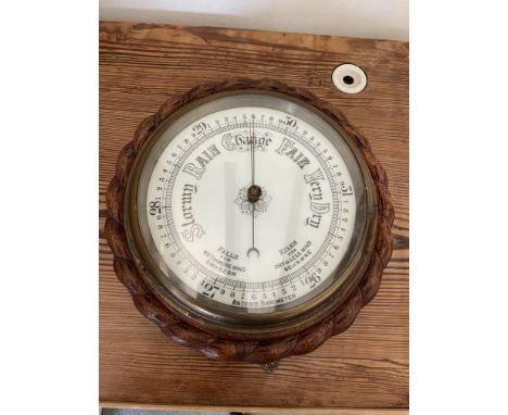 E Bacon and co Aneroid barometer in oak rope edged case. 20 cm dial.