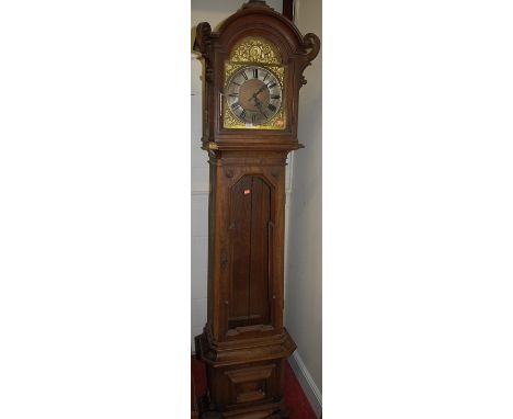A circa 1900 Continental geometric moulded oak longcase clock, having an arched brass and silvered dial, glazed trunk door, w