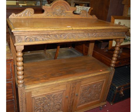 A circa 1900 floral relief carved oak ledgeback buffet, having bobbin turned supports over twin lower cupboard doors, width 1