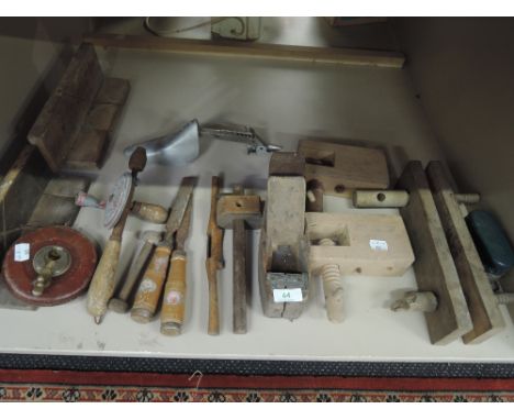A selection of vintage tools including wooden clamps, tape measure and block plane