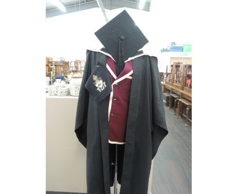 An academic robe, sash and mortar board accompanying certificate and photograph