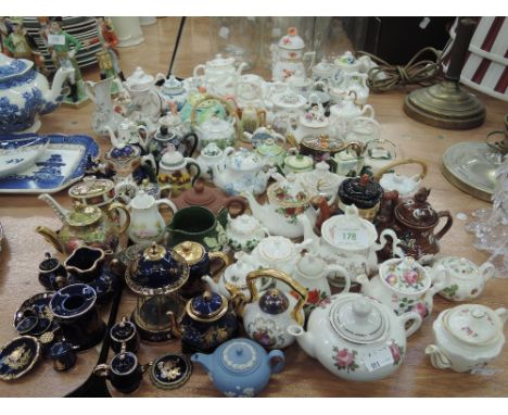 A large collection of miniature tea pots includin Royal Crown Derby, Royal Worcester Fruit study etc 