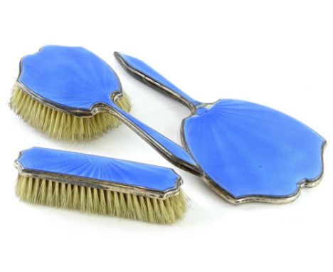 A silver mounted part dressing table set, with blue guilloche enamel decoration, comprising hand brush, clothes brush and a m