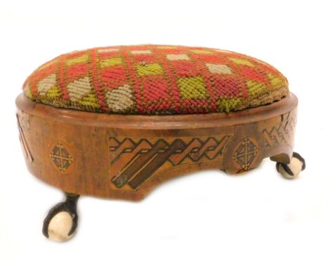 A Victorian walnut and parquetry footstool, with a wool work seat on gilt metal  ceramic ball and claw feet, 31cm dia.