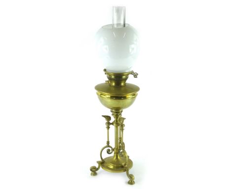 A Hinks brass oil lamp, with opaque globular shade, the base decorated with flames etc., on leaf cast bun feet, 69cm H overal