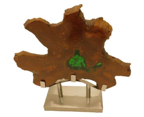 An abstract wood sculpture, made from a slice of a trunk, inset to centre with green crackled perspex on an aluminium base, 7