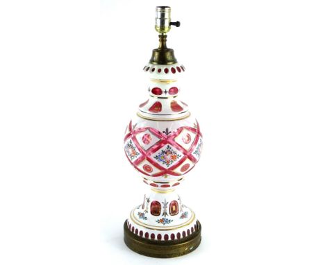 A cranberry tinted and white glass overlay table lamp, decorated with flowers etc., in the Bohemian style, 56cm H.