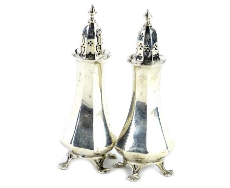 A pair of Art Nouveau style George V silver pepper pots, of facet form, with pierced feet, London 1905, made by the Goldsmith