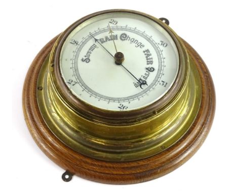 A brass cased aneroid barometer, with circular oak mount, 25cm Dia. 
