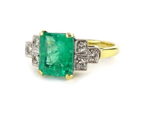 An emerald and diamond ring, with central rectangular cut emerald, in yellow gold claw setting, approx 2.51cts, with round br