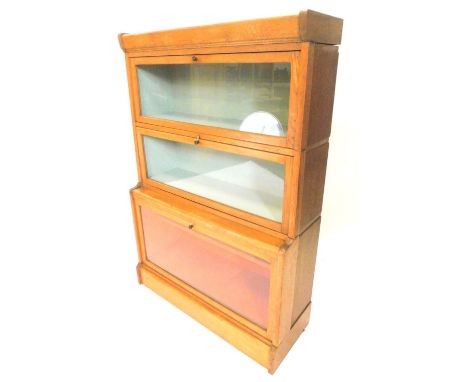 A Globe Wernicke type oak three tier bookcase,  with three glazed doors, on plinth base, 84cm W.