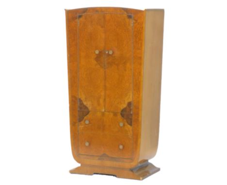 An Art Deco figured walnut small wardrobe, with two doors, above two drawers on a shaped base, 86cm W.