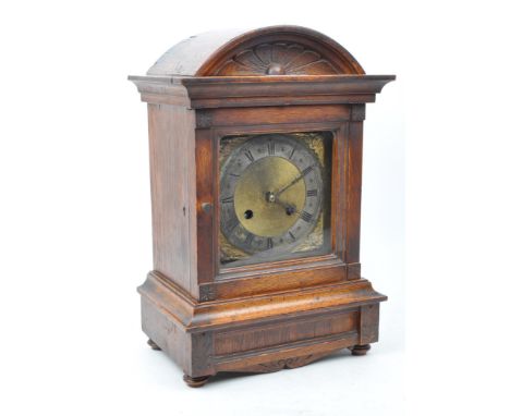 An early 20th century oak cased eight day movement mantel clock. Moulded floral motif to top, with gilt face and ebonised Rom