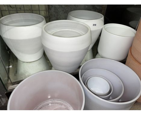 SHELF OF WHITE POTTERY PLANTERS 