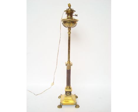 A late Victorian gilt metal telescopic Corinthian column table lamp, the foliate repousse decorated brass reservoir fitted wi