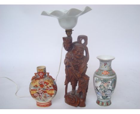 An Oriental carved hardwood figure of Buddhist deity with a Fo dog, fitted as a tabled lamp, a Japanese moon vase and a Chine