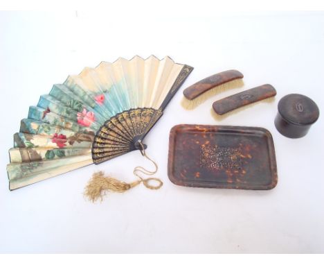 A four piece Edwardian tortoiseshell dressing table set comprising a rectangular tray with raised edge and central carved and