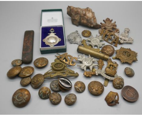 Military cap badges, a piece of schrapnel and a silver fob medal 