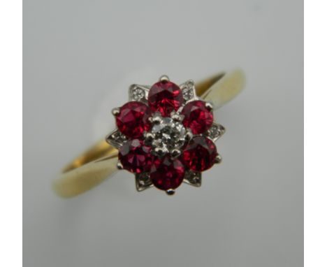 An 18 ct gold ruby and diamond cluster ring. Ring Size N.