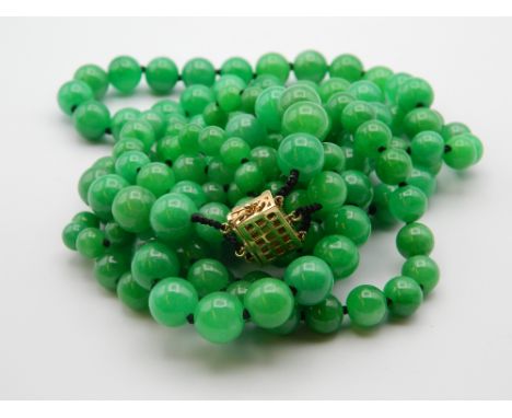 A three strand jade bead necklace with a 14 ct gold and diamond clasp. 50 cm long.