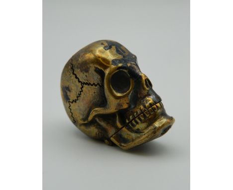 A brass vesta formed as a skull. 4 cm high.
