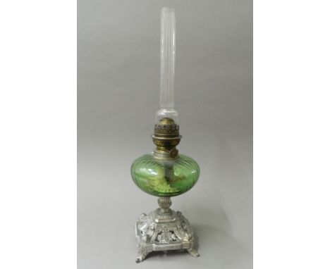 A Victorian oil lamp with green glass reservoir. 52 cm high.