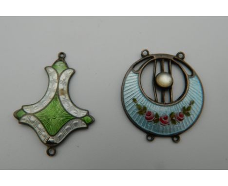 Two Art Nouveau enamel decorated silver pendants. The largest 3 cm high.