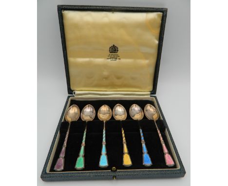 A cased set of silver and enamel spoons.