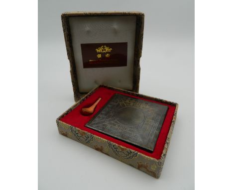 A boxed Chinese model of an ancient compass.