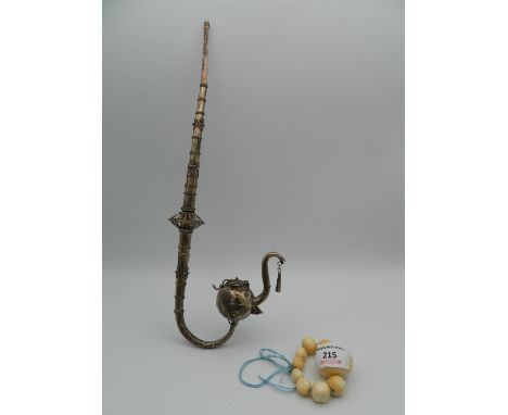 An Oriental white metal pipe and a set of 19th century ivory prayer beads. The former 33 cm long.