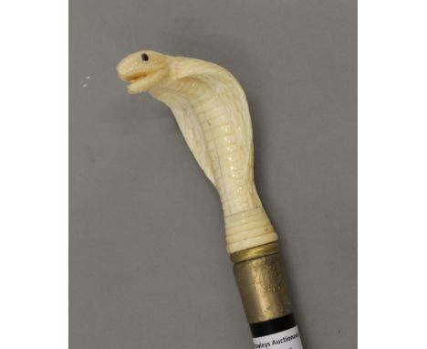 A walking stick with a carved bone handle formed as a cobra. 89 cm long.