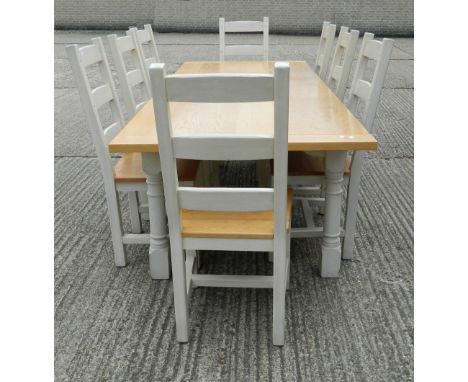 A modern white painted oak dining table and a set of eight ladder back dining chairs. The table 244 cm long x 98 cm wide.