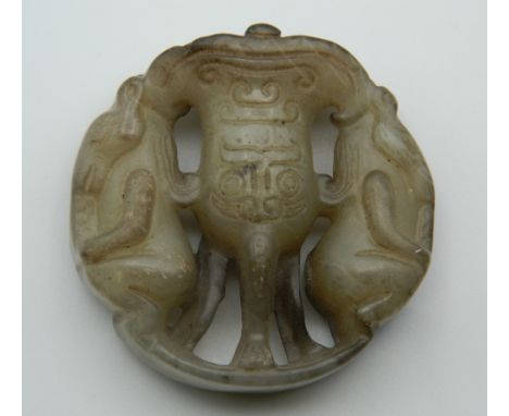 A Chinese carved jade roundel. 5 cm high.