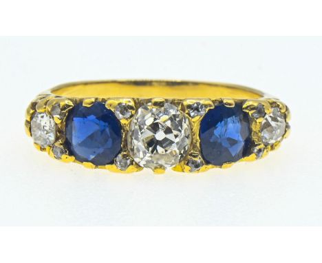 Yellow metal diamond and sapphire ring. The central old cut diamond measures approximately 5.5 x 5mm diameter . The sapphires